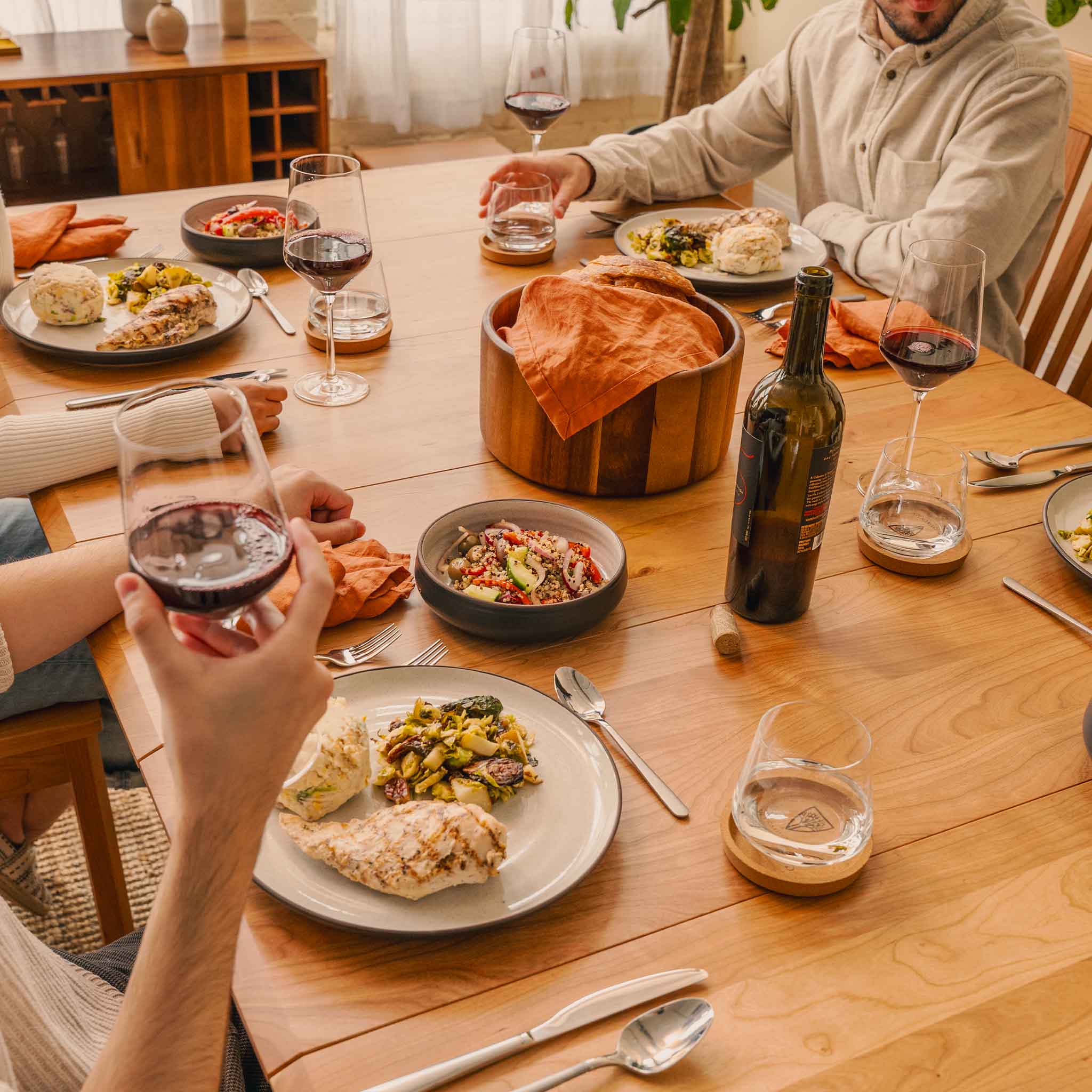 Friends sharing a meal around a Wyrmwood table